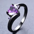 Nahaufnahme eines herzförmigen lila Zirkons auf einem eleganten schwarzen Ring - Größe 7 / Schwarzgold Lila Zirkonia