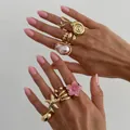Set of golden ocean-themed rings featuring starfish and shell designs on model hands - Gold + Pink-07031