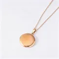 Detail view of polished rose gold round photo locket necklace with mirror finish surface - Plain Round Locket (Pinch Bail + Flat Cross Chain) / Rose Gold