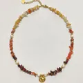 Detalle de collar de piedras naturales con un colgante de sol en oro martillato a mano. - Estilo Colgante Disco Redondo de Piedra Triturada / 38+5cm