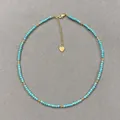 Close-up detail of handmade turquoise and gold beaded necklace with heart charm. - Necklace / 38+5cm / Turquoise and Gold