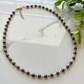 Faceted dark stone beaded necklace with colorful spacers and gold-tone clasp detail. - Necklace / 38+5cm / Black, Brown and Multicolor Beads