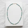 Detailed view of turquoise beaded necklace featuring faceted gold spacer beads on stone - Necklace / 38+5cm / Turquoise