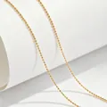 Close-up detail of a minimalist gold-plated titanium steel ball chain necklace jewelry - 40+5cm / Ball Chain / Gold