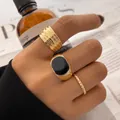 Set of vintage gold rings featuring a black enamel signet ring and textured bands - 53467
