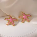 Gros plan détaillé de boucles d'oreilles étoile de mer en émail rose et acier doré. - Boucles d'Oreilles Clous Étoile de Mer en Émail Rose Clair (2174)