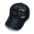 Détail d'une casquette en dentelle noire avec décoration LOVE en strass - Noir Strass LOVE Logo / Adulte, Circonférence du chapeau 58cm réglable