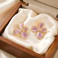 Close-up detail of lavender enamel cherry blossom earrings in a wooden gift box. - Cherry Blossom Style / Purple