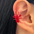 Close-up detail view of a vibrant red spider-shaped ear cuff on a female model's ear bone. - Spider Style (10762) / Red