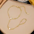 Dettaglio di un bracciale da mano in acciaio inossidabile dorato con zirconi brillanti - Stile Strass Bianco Perlina Dorata (E2560)