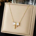 Detailed close-up of a gold bowknot pendant necklace with sparkling zircons on a gift box. - Heart Zirconia Bowknot Luxury Style (N4542)