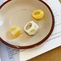 Detailed shot of three resin rings with yellow and marble textures in a ceramic dish - Marble Pattern Marbled Ring (22#)