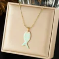 Close-up of the striped fish enamel pendant on a gold necklace displayed in a box. - Teal and White Striped Fish Enamel Pendant (N4531)
