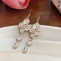 Dettaglio di orecchini a fiore in argento con pendenti a goccia e ganci eleganti. - Ganci per orecchini - Argento