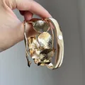 Vue détaillée d'un ensemble de bracelets en métal doré texturé tenus à la main - Style 9 Bangle / Set de 4 pièces / Or