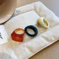 Detail of three chunky resin rings in amber, black, and marbled cream on a pouch - Thickened Geometric Design Style (16#)