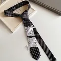 Gedetailleerd overzicht van een vintage stippen stropdas met kant en strikjes voor dames. - Zwart Met Witte Stippen