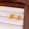 Primo piano di orecchini a goccia gialli a pois marroni su un vassoio per gioielli - Gancio per Orecchio-Argento (HE35030) / Giallo