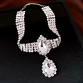 Close-up of sparkling teardrop crystal pendant on multi-row rhinestone necklace - Silver