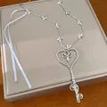 Primer plano del collar elegante con colgante de llave de corazón con perlas y flores - Plateado
