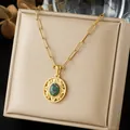 Close-up of a vintage gold-plated necklace with an oval stone pendant on a beige box. - Ruby in Zoisite Oval Carved Necklace (N4557)