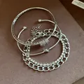 Primo piano di un set di quattro bracciali argentati con strass e catene - Argento
