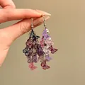 Primer plano de pendientes de borla de mariposa hueca de colores en la mano - Estilo de Gancho para la Oreja / Rosa Púrpura