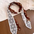 Close-up detail van een bruine zijden sjaalketting met stippen en witte kanten rand - Stippen / Koffie en Groen