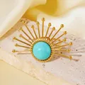 Makroansicht eines vergoldeten Sonnenrings mit Türkisstein auf einem Steinständer präsentiert. - Gold Sonnenblume Stil