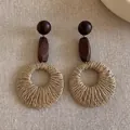 Detailed close-up of bohemian earrings with wooden beads and woven raffia rings - Style 5 (Round) / Brown