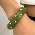 Close-up detail of retro green acrylic wide bangle with embedded golden round studs - Green With Dots (WG-1170)