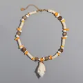 Dettaglio della collana fatta a mano con ciondolo a conchiglia e perline bohémien colorate. - Collana con Conchiglia e Scaglie di Pietra