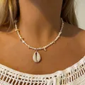 Gedetailleerde close-up van een schelphanger ketting met witte parels op een model. - Zoetwaterparel Schelp Wulk Ketting / 43cm / Melkwit