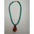 Vista dettagliata della collana artigianale turchese con ciondolo a conchiglia marrone lucido - Collana con Conchiglia Marrone e Perle Distanziatrici