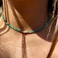 Dettaglio di collana di perle turchesi con piccole conchiglie su pelle bagnata - Collana di Perline Mini Conchiglia - Turchese