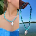 Collana da spiaggia con perline blu e ciondolo a conchiglia bianca indossata da modella - Collana con Conchiglia e Guscio Blu
