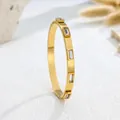 Detailed macro shot of a minimalist gold stainless steel bangle with elegant crystal inlays - White Rhinestone Gold Style