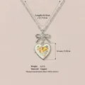 Collana vintage con medaglione a cuore argento con fiocco e design a cherubino deco - Pendente Medaglione Cuore Fiocco Angelo / Colore acciaio