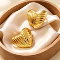 Macro view of golden ribbed heart-shaped stainless steel earrings on luxury satin cushion - Line Heart