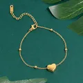 Elegant 18K gold plated heart charm bracelet with round beads on green background - Heart Bead Bracelet