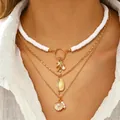 Collana bohémien a strati con perline bianche e ciondoli a conchiglia dorati su pelle - Collana Multistrato Oceano Heishi Bianco (11110)