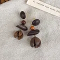 Handcrafted vintage brown geometric wooden drop earrings displayed on natural linen cloth - Hollow Bud Geometric Style (28420A)
