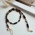 Vue détaillée du collier de perles en œil de tigre vintage avec chaîne en acier titane doré - Oeil de Tigre Carré / 38+5cm / Brun Foncé
