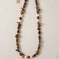 Gros plan d'un collier vintage en œil de tigre et perles avec pendentif cœur doré - Perle Éclats Oeil de Tigre / 38+5cm / Brun Blanc Or