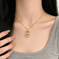 Primo piano che mostra l'effetto elegante di indossare la collana con ciondolo a orso d'oro. - Orso Oro (L0030)