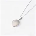 Detail view of a polished silver-colored stainless steel oval locket necklace on a chain - Silver