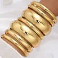 Chunky golden polished metal bangle set for women featuring stacked wide and thin bracelets - 6790601HB
