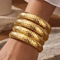 Set of four thick gold-tone hammered metal bangles for a bold fashion statement - 6796701HB