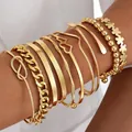 Multi-piece gold metal bracelet set with heart and knot designs on female arm - 6794301HB