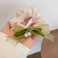 Elegante scrunchie crema con fiocco verde a strati e ciondoli a mughetto, stile bosco - Elastico per Capelli Mughetto / Bianco avorio